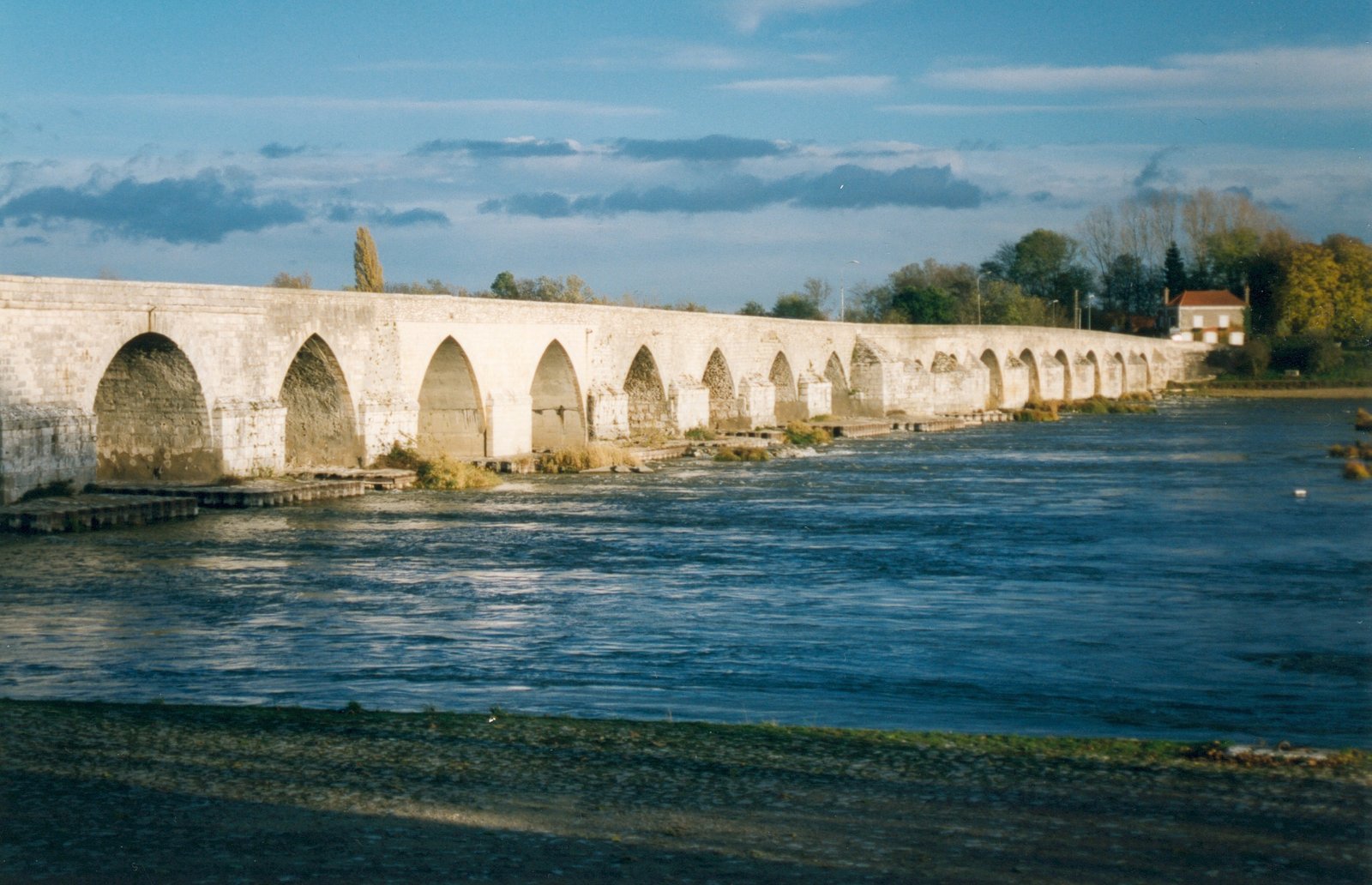 Les arches de pierre du pont de Beaugency franchissant la Loire sous un ciel de fin de journée